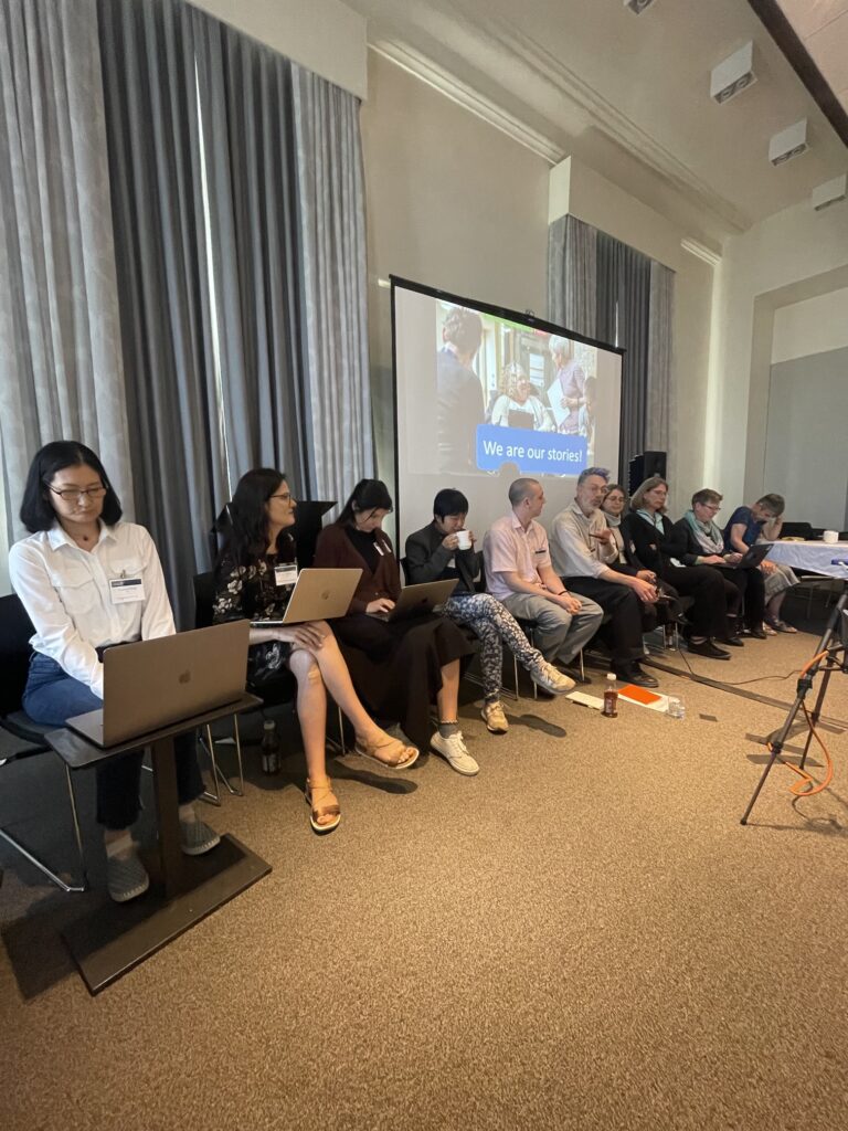 a group of people sit in a row at the front of the room for a panel discussion